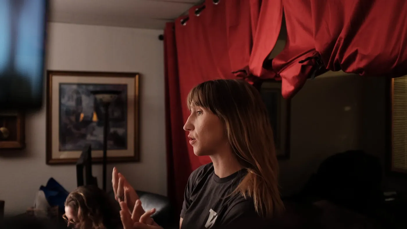 An interviewee in profile in front of a red curtain